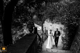 The bride and groom take a romantic post-ceremony stroll together, walking hand-in-hand through the historic and majestic grounds of the Castello di Duino in Duino, Trieste, Italy.
